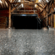A London polished concrete floor reflects the wooden beams and industrial loft interior of a renovated building. The text Grinding & Polishing appears at the bottom.