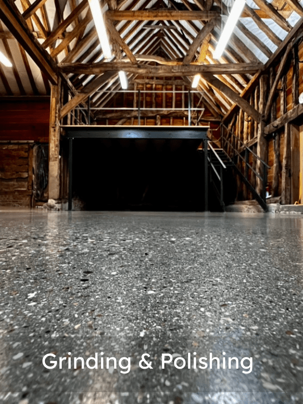 A London polished concrete floor reflects the wooden beams and industrial loft interior of a renovated building. The text Grinding & Polishing appears at the bottom.
