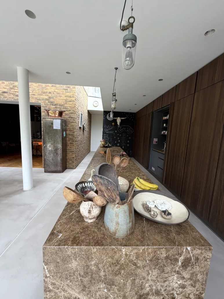 Microcement floor meeting a marble kitchen island in a London residence