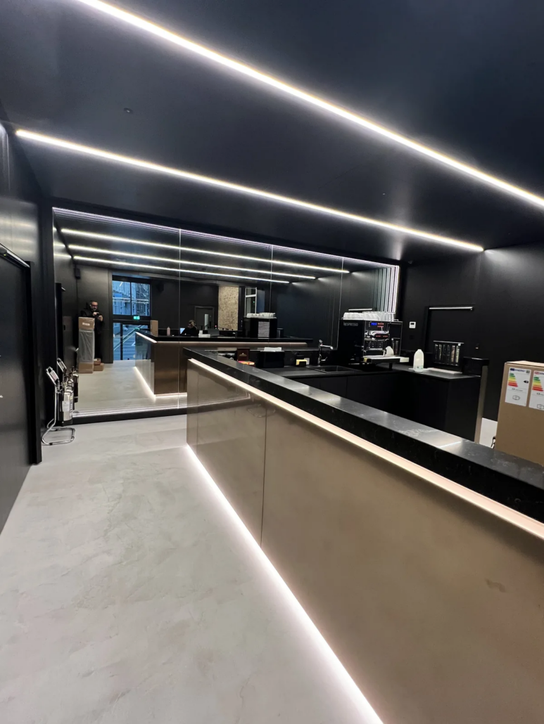 Coffee bar with microcement floor and LED-lit counter — Lotus Cars London HQ